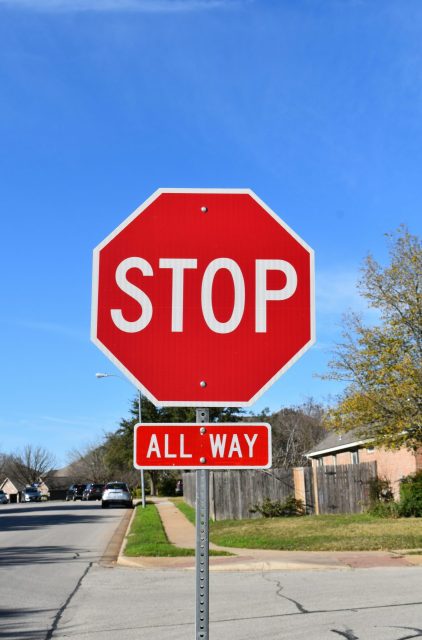 青空の下に立つ赤いSTOP標識