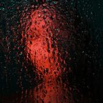 雨粒越しにぼやけた人物のシルエット｜ナイフに襲われる夢の不安