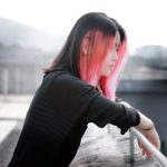 手すりにもたれて考え込む女性のイメージ