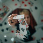 暗闇でカードを操る手。マジシャンの夢は、見えない努力や仕込まれた意図を表します。