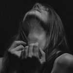 首元を押さえる女性。首を噛まれる夢が示す精神的圧力のイメージ
