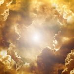 金色の雲の切れ間から強い光が差し込む空