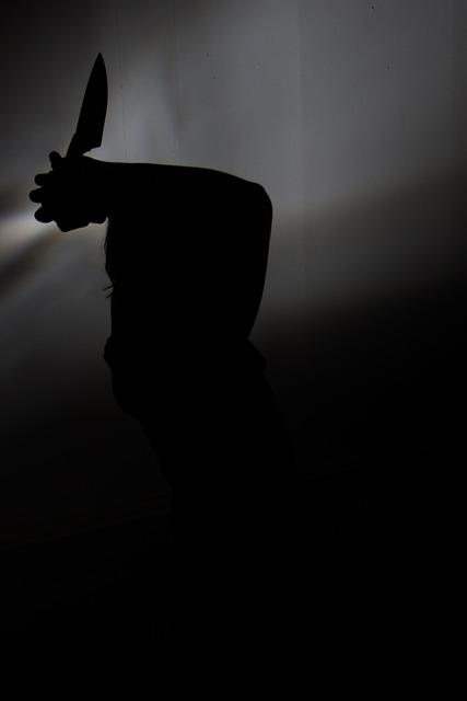 暗闇の中でナイフを振り下ろそうとする人物