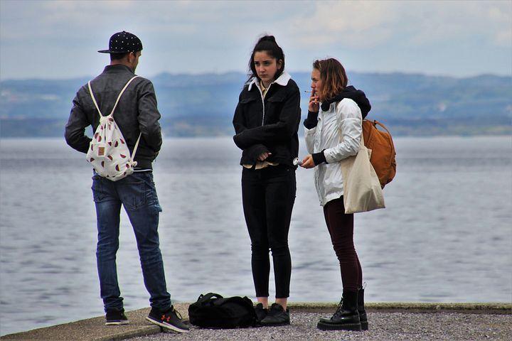 海の近くで、一人の男性が2人の女性に追い詰められている