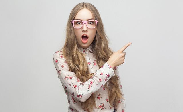 驚いた表情で指をさす女性―言いがかりをつけられる夢の象徴