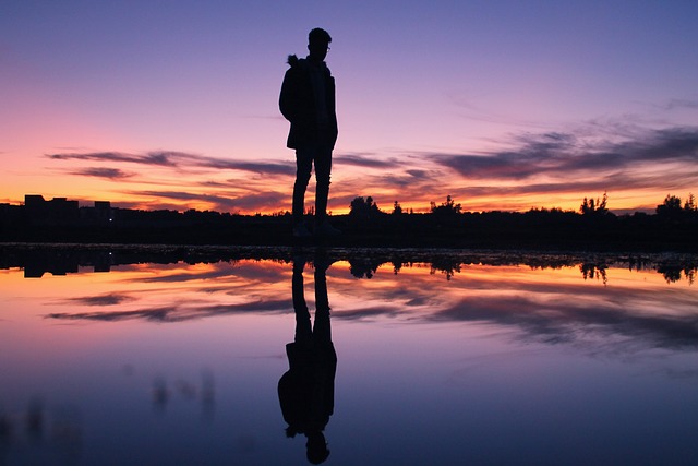 幻想的な景色と湖面に映った自分の姿を見つめる男性