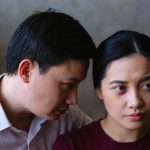 耳元で何かを囁かれ、不安げな表情を浮かべる女性。 人間関係での圧力や支配、恐怖を象徴する夢のイメージ。 A man whispering into a woman’s ear while she looks anxious, symbolizing fear, manipulation, and pressure in dreams.