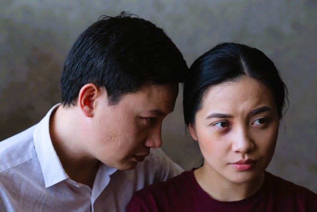 耳元で何かを囁かれ、不安げな表情を浮かべる女性。 人間関係での圧力や支配、恐怖を象徴する夢のイメージ。 A man whispering into a woman’s ear while she looks anxious, symbolizing fear, manipulation, and pressure in dreams.