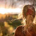 夕暮れの水辺で遠くを見つめる人物、射手座の探究心と内なる旅を象徴する風景