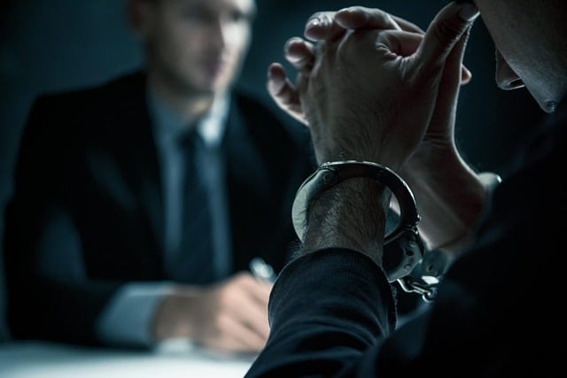手錠をはめて尋問を受ける人と尋問する人