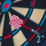 狙いを定めさせられるゲームのように、結果を求められる心理状態を象徴するダーツの的 