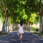 並木道を一人で歩く女性・距離を取ることで見つける自由の夢イメージ