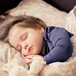 ぬいぐるみを抱いて眠る子ども。夢は記憶に残らなくても、心を整えるために通過していくものを象徴する