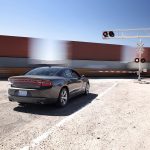 踏切で列車の通過を待つ車の様子