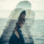 海を背景に、顔が幾重にも重なって見える女性のポートレート