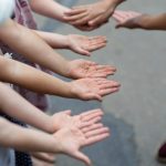 差し出された子どもたちの手