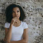 夢の中の違和感や迷いを表すように考え込む女性