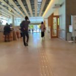人が行き交う明るい公共施設の通路