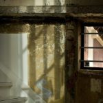 壁が剥がれた古びた建物の階段横