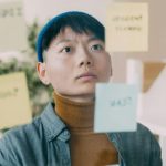 付箋を前にして、たくさんの情報や課題を整理しようとしている人のイメージ
