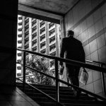 何かを持って出てくる夢を表す、建物の階段を上る人物のモノクロ写真