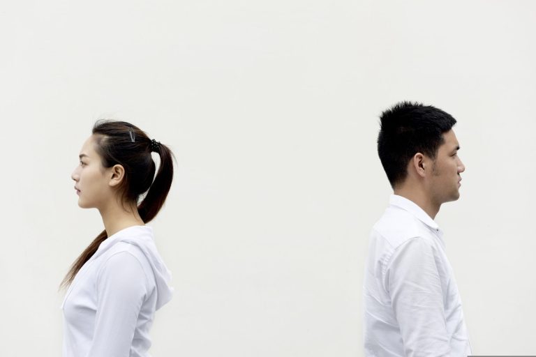 背中合わせに立つ男女が、タイプではない人と付き合う夢の違和感を表している