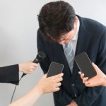 謝罪会見で頭を下げる人、失言や世間から非難される夢を象徴する画像